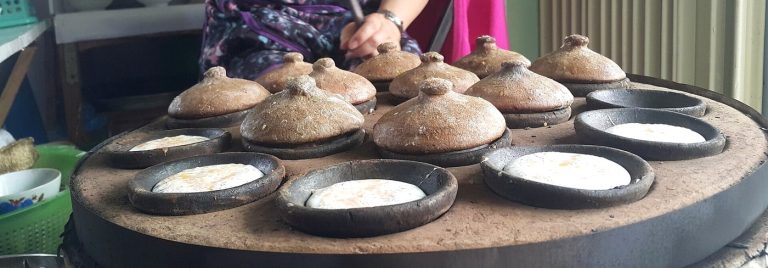 Bột bánh căn đang chín trong những khuôn nhỏ có nắp đất nung