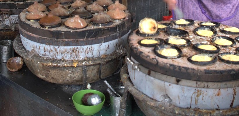 Các mẻ bánh căn bên cạnh khuôn đất còn đậy nắp