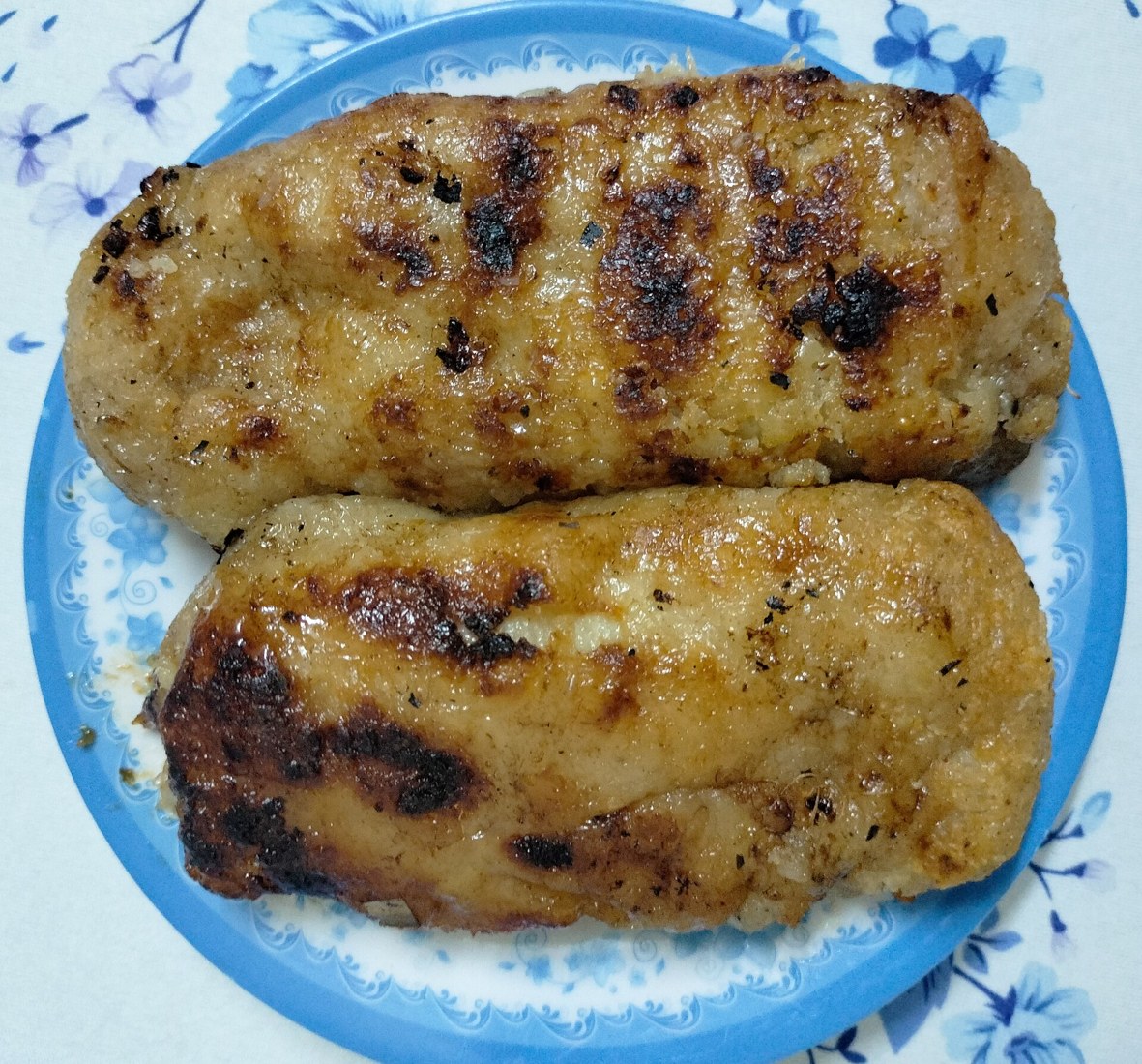 Hai phần chuối nếp nướng trên đĩa, chưa rưới nước cốt dừa